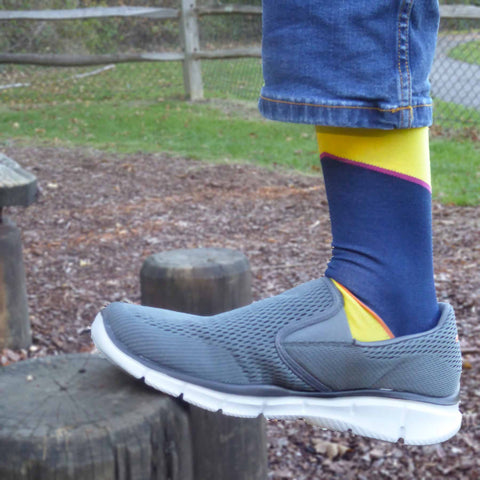 Man wearing Peper Harow bumblebee Hilltop luxury socks standing on a log