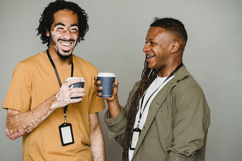 two-men-holding-coffee-cups-laughing