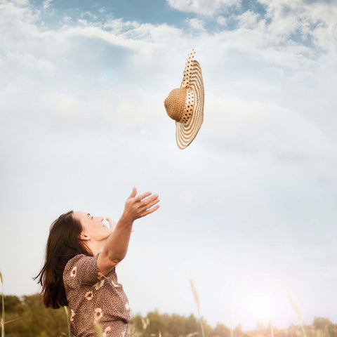 Woman throwing her hat into the air