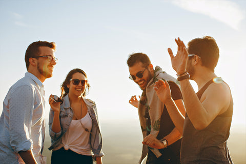 four-people-standing-together-laughing