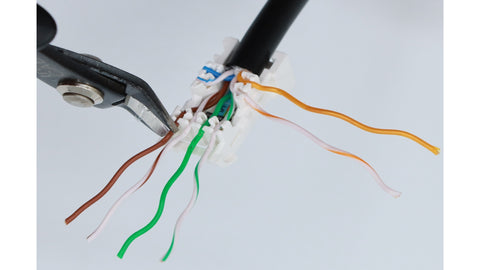 Once the conductor pairs are fully seated, trim the excess conductor wires.  Trim the front wires are shown (top-down, not straight across).
