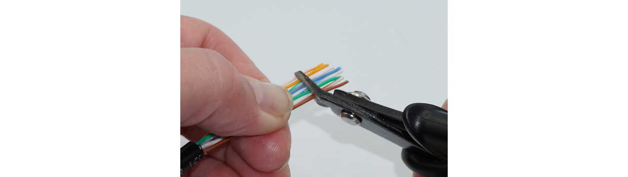 Locate a good spot, about 1.5 to 2” away from the cable jacket, to flush cut the conductors. T568B sequence shown. I like to work from top down (if I can). White-orange at the top, and solid brown at the bottom.