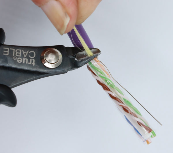 Removing the ripcord from the shielded cable jacket