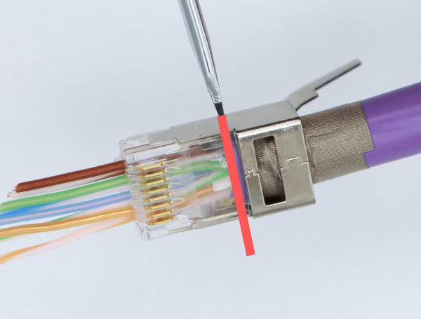 Insert the cable jacket into the plug housing to the depth indicated.  You will feel a hard stop point.  You want to see a small amount of cable jacket color just after the metal.  Stop there.