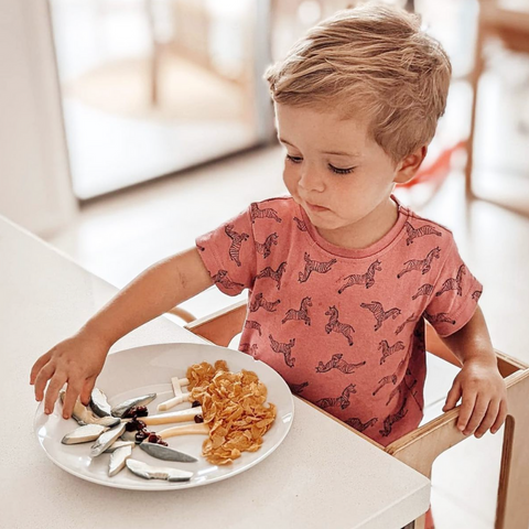 Toddler Eating plate of food with fun shapes