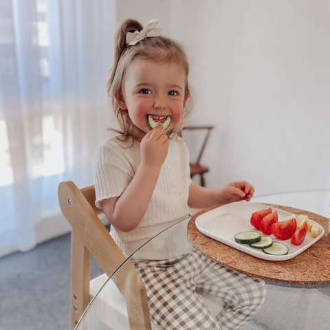 Child eating veggies at table