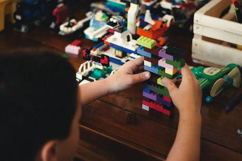 Child assembling Lego pieces 