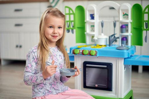 child playing with toy kitchen