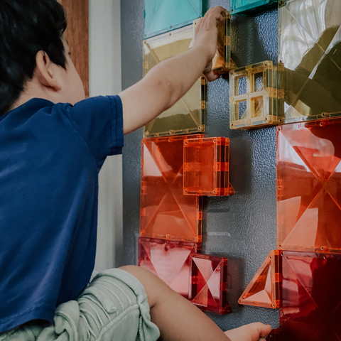 Toddler playing with magnetic tiles