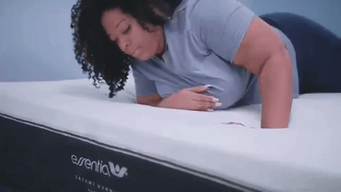 Woman who is heavier testing an Essentia mattress