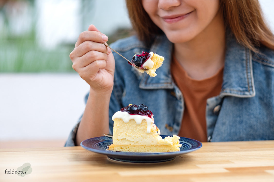 A woman smiling as she is about to eat a slice of cake