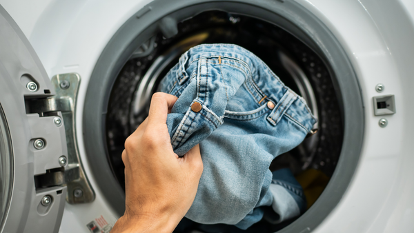 image of jeans going into the washing machine