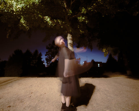 a person shot using slow shutter speeds at night with a flash at a park.