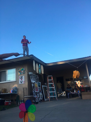 latino man on top of the house setting up the piñata pinata for children's birthday party