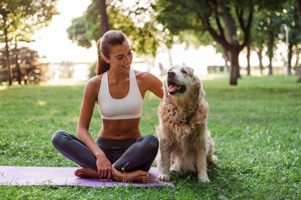 woman in her yoga gear spending quality time with her pet dog
