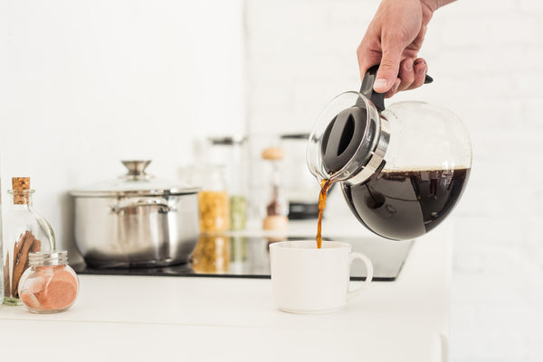 Person Pouring Coffee Into a Mug