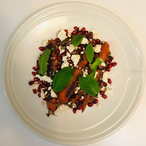 Salad with carrots, feta cheese, pomegranate seeds, and mint leaves.