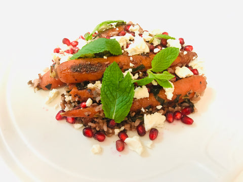 Salad with mint leaves, carrots, pomegranate seeds, and feta cheese.