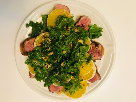 Duck and Orange salad with kale, oranges, duck, walnuts, and baguette slices