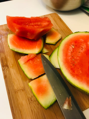 Peeled chunk of watermelon on a bamboo cutting board
