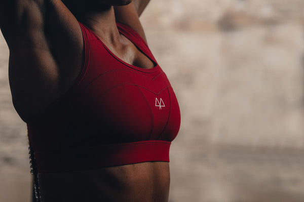 Stretching in a red sports bra