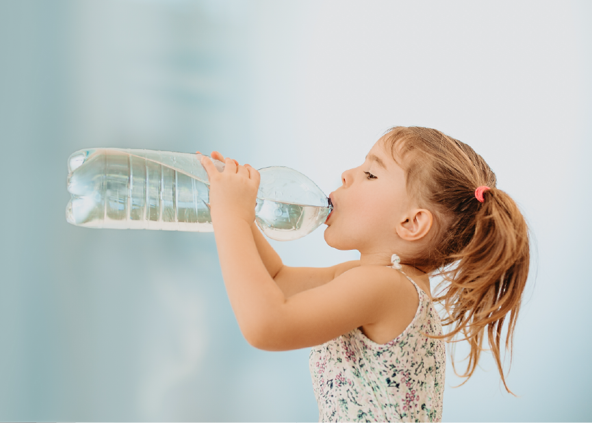 giovane ragazza che beve una grande bottiglia piena di articoli