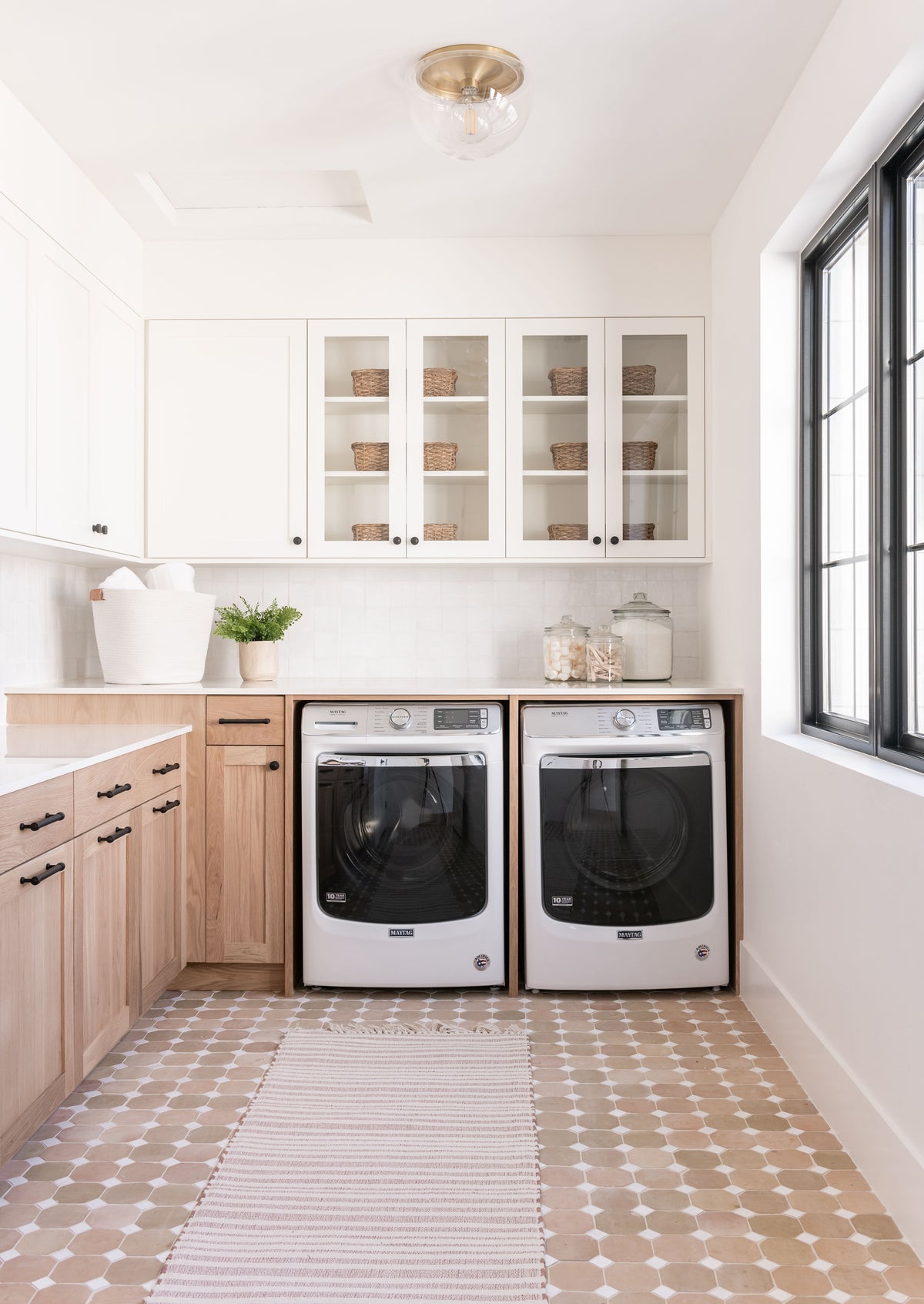 A soft neutral beigy-pink tile floor in a laundry room.