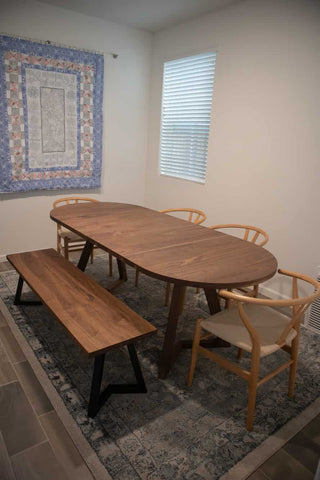 A Bench besides a Racetrack Oval Dining Table