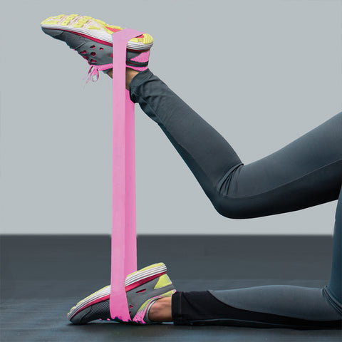 Athlete stretching a pink resistance loop with their legs