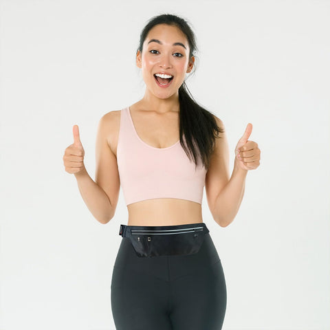 Female athlete wearing a waist pack giving two thumbs up
