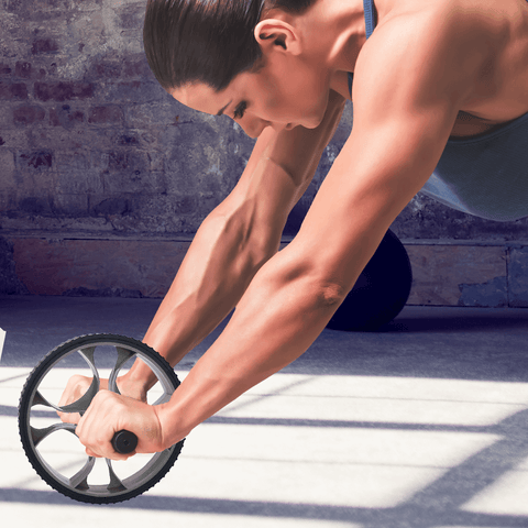 Athletic woman rolling an ab wheel