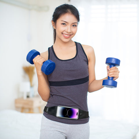 Female athlete holding dumbbells and wearing a black waist pack