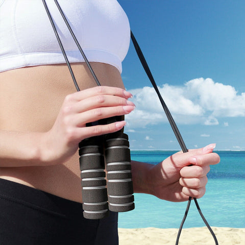 Woman on the beach with a jump rope around her neck