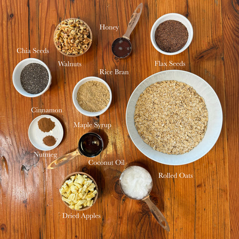 Ingredients for apple cinnamon walnut granola arranged in bowls with labels