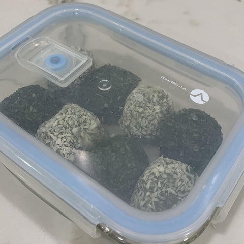 Green matcha balls inside a container ready for freezing.