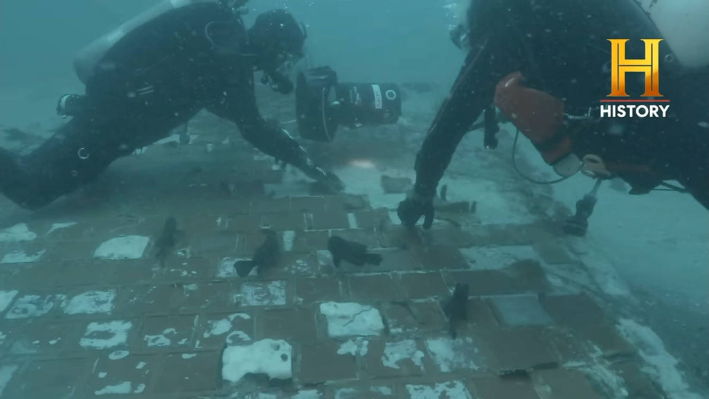 divers uncovering wreckage piece of the Challenger Space Shuttle