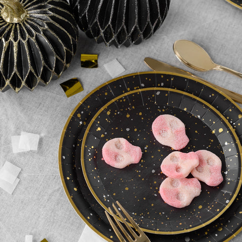 Gold and silver metallics on black plate with pink sour Halloween candy