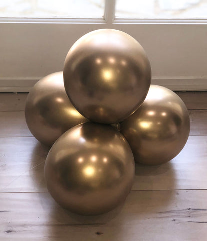 A stack of 4 gold balloons tied together.