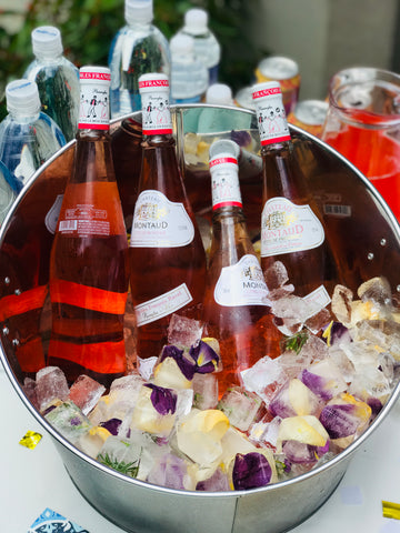 Rosé bottles in ice bucket with floral ice cubes.