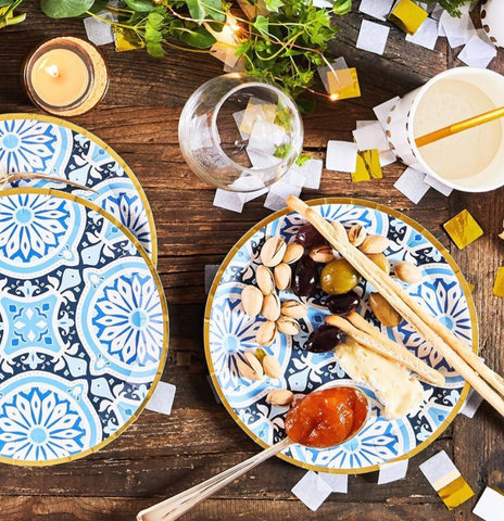 Italian-styled paper plates with gold cutlery, straw and cup accents. Confetti and candles wrapped around garland.