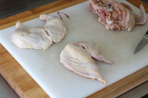chicken breast removed from chicken body on cutting board