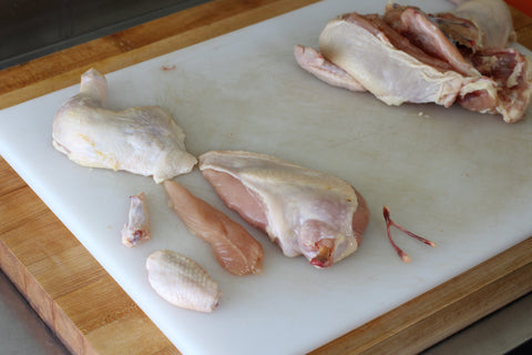 chicken pieces butchered separate lying on cutting board