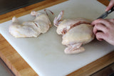 cutting off chicken breasts with knife