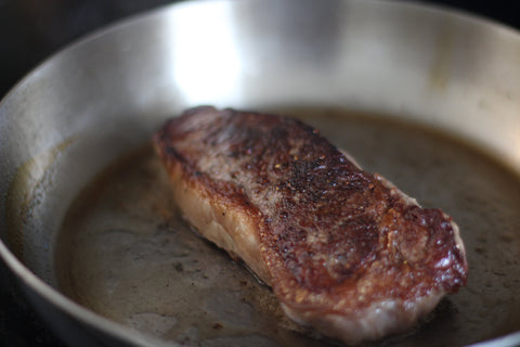 perfectly seared new york steak in pan