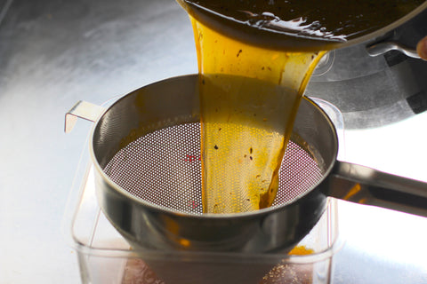 straining beef stock through china cap