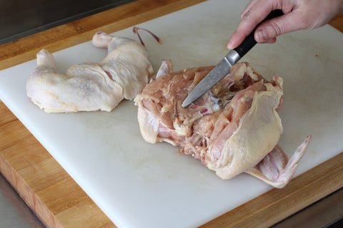 slicing the chicken breast from the body