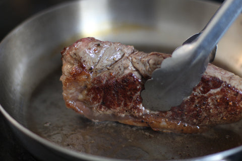rendering searing fat cap of new york steak