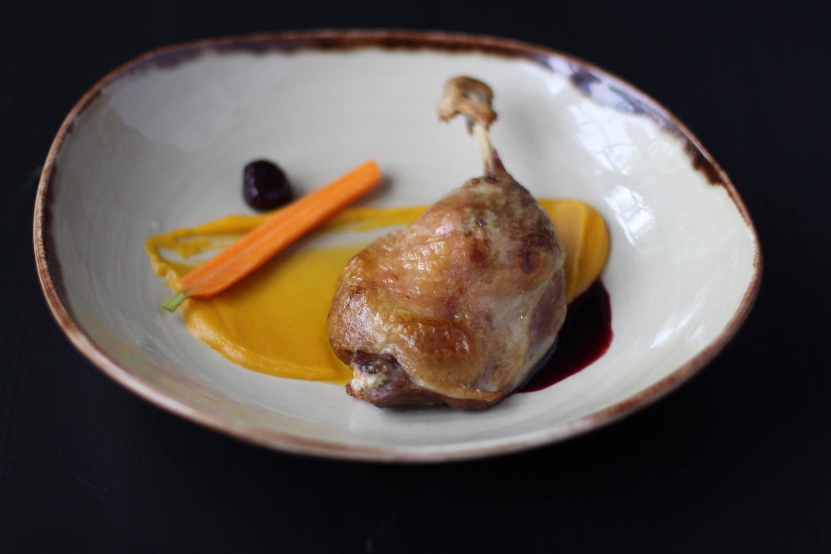 Crisp duck confit on brown butter butternut squash puree with a cherry gastrique