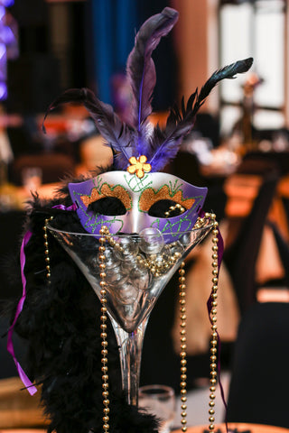 Mardi Gras decor with mask, beads, and martini glass.