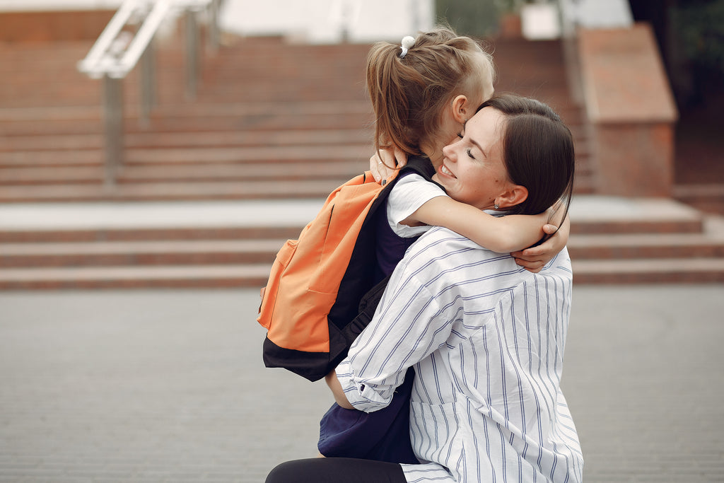 school kid hugging mom